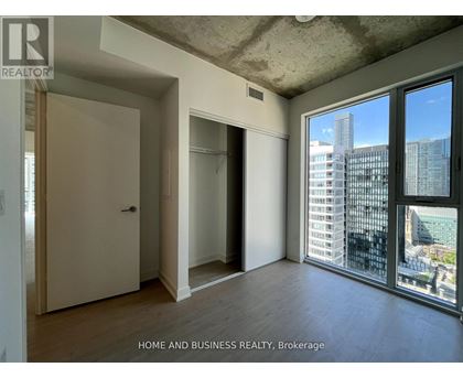 A room with a view of the city through large windows.