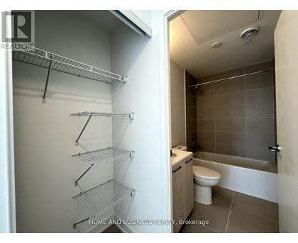 A bathroom with a walk-in shower and a pantry with shelves.