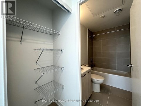 A bathroom with a walk-in shower and a pantry with shelves.