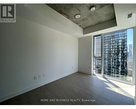 A spacious room with a view of the city through large windows.