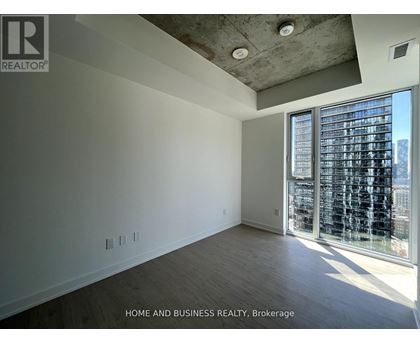 A spacious room with a view of the city through large windows.