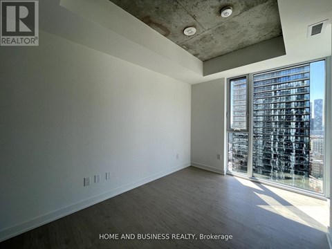 A spacious room with a view of the city through large windows.
