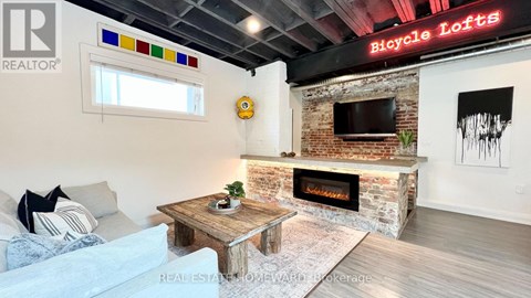 A living room with a fireplace and a sign that says Bicycle Lofts.
