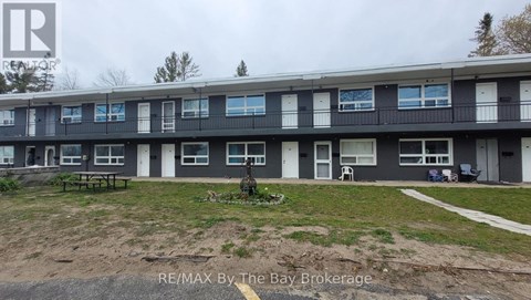 Apartment complex with a grassy area in front.