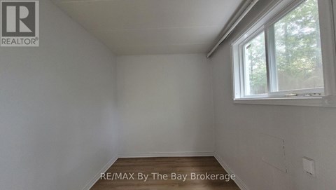 A white room with a window and a Realtor logo.