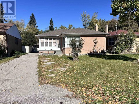 A house with a driveway and a tree in front of it.