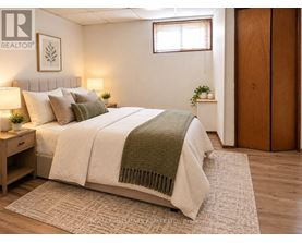 A bedroom with a bed, nightstand, and a window.