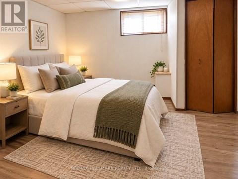 A bedroom with a bed, nightstand, and a window.
