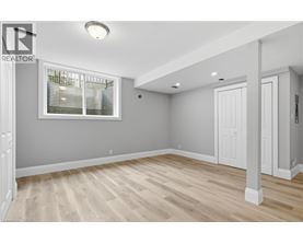 A room with wooden flooring and a window with blinds.