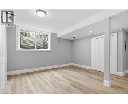 A room with wooden flooring and a window with blinds.