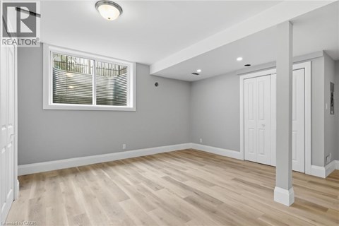 A room with wooden flooring and a window with blinds.