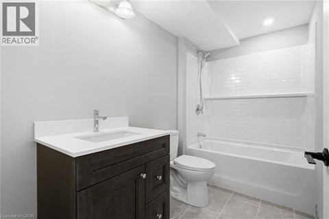 A bathroom with a toilet, sink, and bathtub.