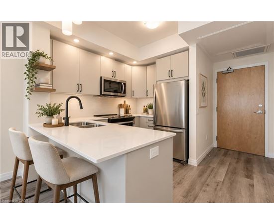 A modern kitchen with a white countertop and stainless steel appliances.