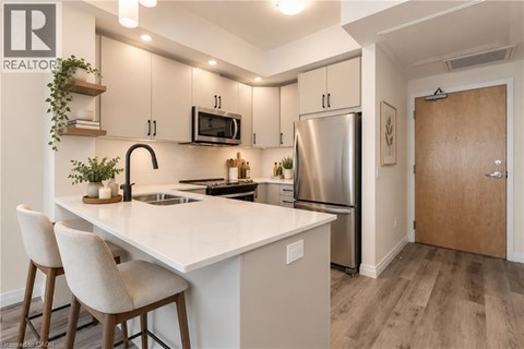 A modern kitchen with a white countertop and stainless steel appliances.