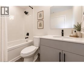 A white toilet in a bathroom with a sink and a mirror.