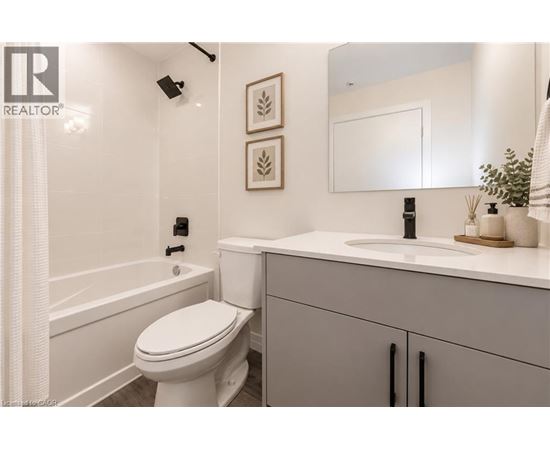 A white toilet in a bathroom with a sink and a mirror.