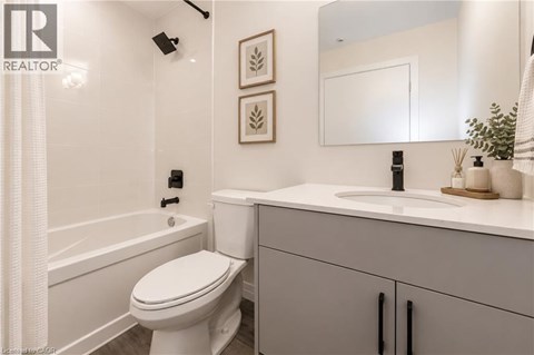 A white toilet in a bathroom with a sink and a mirror.
