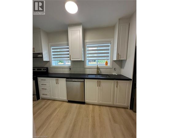 A kitchen with white cabinets and a black countertop.