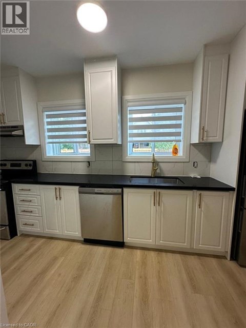 A kitchen with white cabinets and a black countertop.