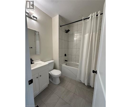 A white bathroom with a toilet, sink, and bathtub.