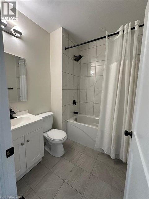 A white bathroom with a toilet, sink, and bathtub.