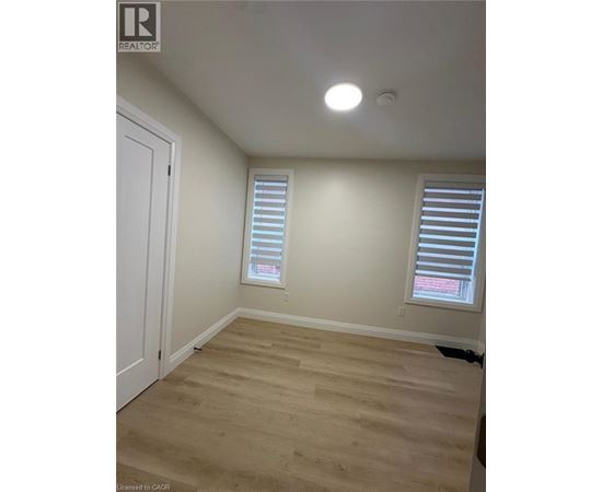 A room with a white door and a window with blinds.