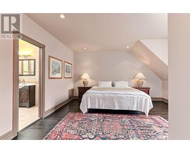 A bedroom with a large bed and a rug on the floor.