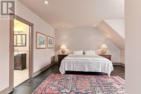 A bedroom with a large bed and a rug on the floor.