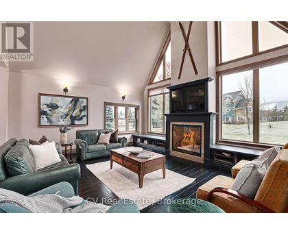 A living room with a fireplace and a painting on the wall.