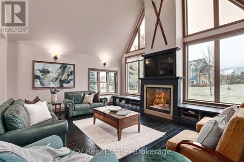 A living room with a fireplace and a painting on the wall.