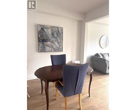 A dining room with a round table and chairs.