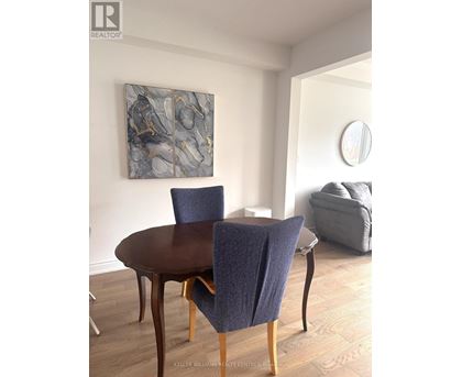 A dining room with a round table and chairs.