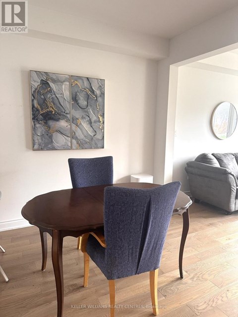 A dining room with a round table and chairs.