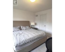 A bedroom with a bed, chair, and lamp.