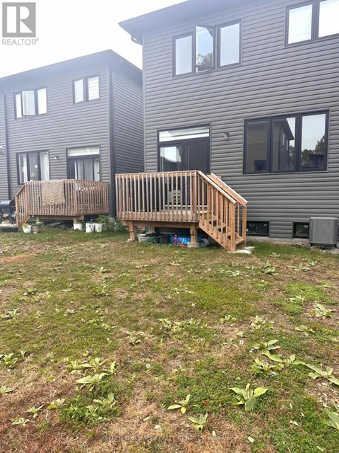 A wooden deck in front of a grey building.