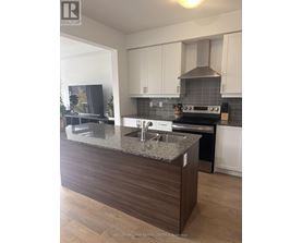 A modern kitchen with a granite countertop and stainless steel appliances.