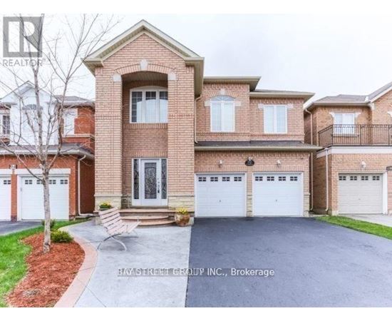 A large brick house with a tree in front and a sign that says "REALTOR".