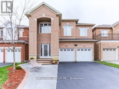A large brick house with a tree in front and a sign that says "REALTOR".