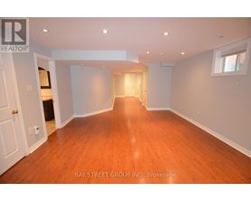 A spacious room with wooden floors and white walls.