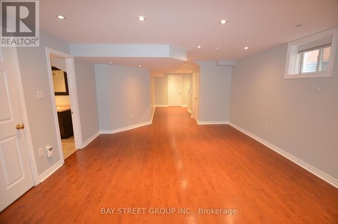A spacious room with wooden floors and white walls.