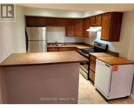 A kitchen with a refrigerator, stove, and cabinets.