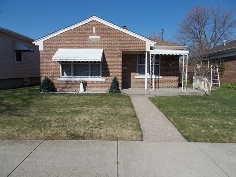 A house with a white awning and a small porch.