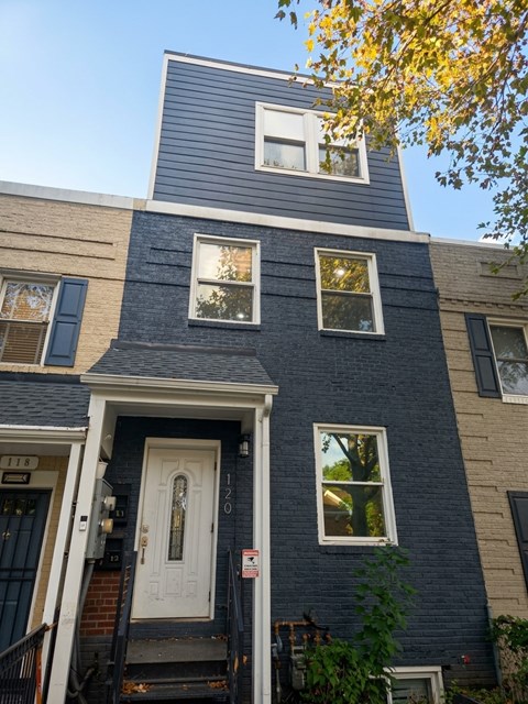 A blue house with a white door and windows.
