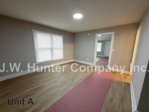 A room with wooden flooring and a window is labeled as Unit A.