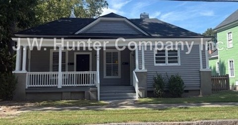A house with a porch and a sign that says J.W. Hunter Company Inc.