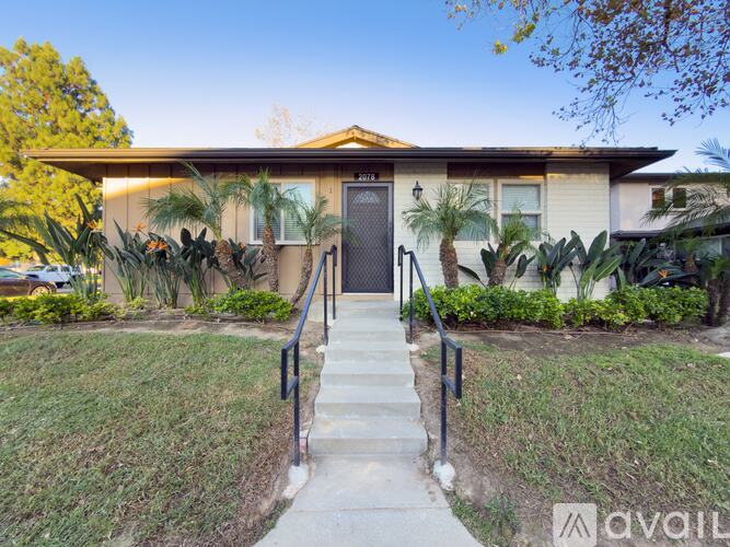 A house with a front yard and steps leading to the front door.