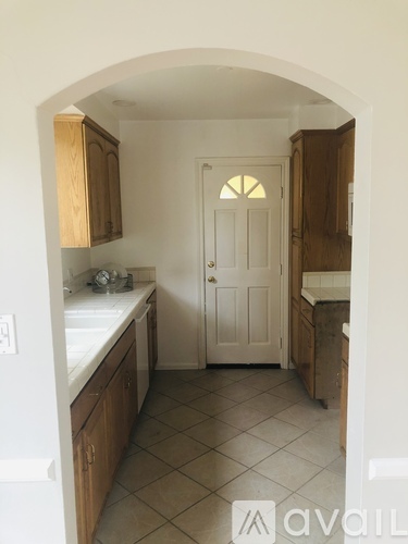 A kitchen with wooden cabinets and a white door.