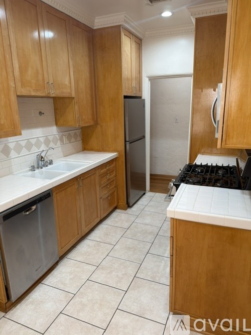 A kitchen with wooden cabinets and a white counter top.