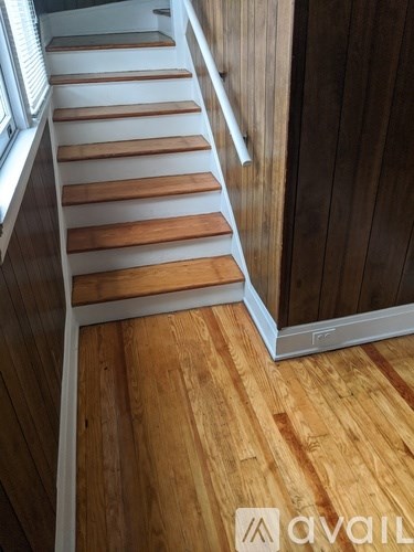 A wooden staircase with a white railing.