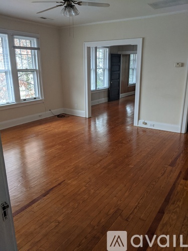 A room with wooden floors and a ceiling fan.